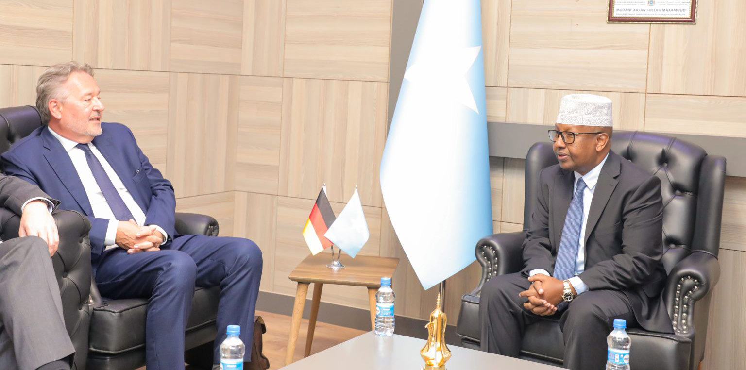 Somalia’s Speaker of the House meeting the German Ambassador, seated in armchairs beside national flags
